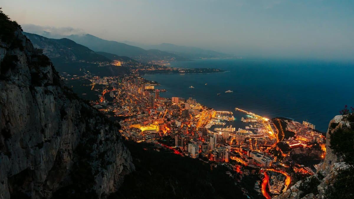 Stunning aerial perspective of Monaco's illuminated harbor and cityscape at twilight.