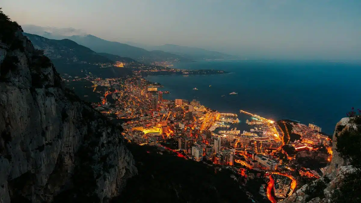 Stunning aerial perspective of Monaco's illuminated harbor and cityscape at twilight.