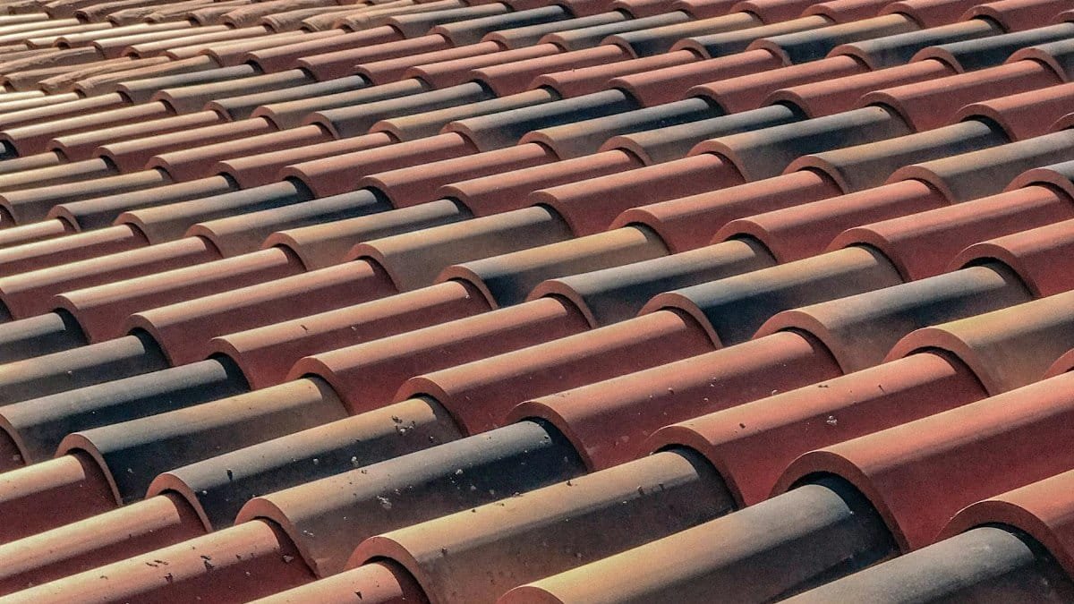 A detailed view of overlapping terracotta roof tiles creating a pattern, capturing a classic architectural style.