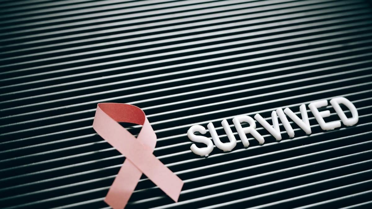 Conceptual image of breast cancer survival with pink ribbon and 'Survived' message.