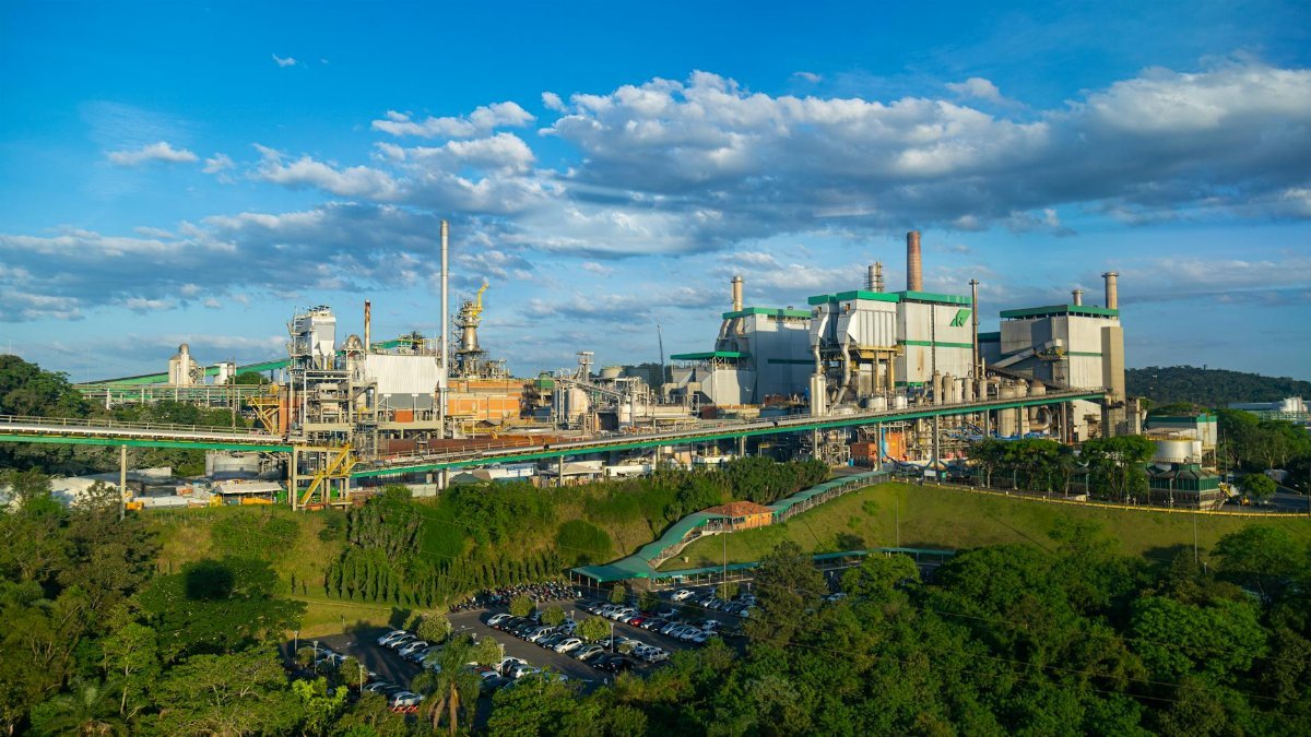 Aerial view of a large factory amidst lush greenery in Telêmaco Borba, Brazil.