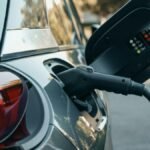 Close-up of an electric vehicle being charged, highlighting modern clean energy technology.