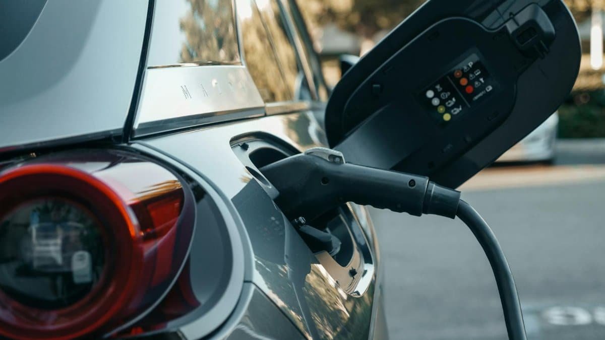 Close-up of an electric vehicle being charged, highlighting modern clean energy technology.