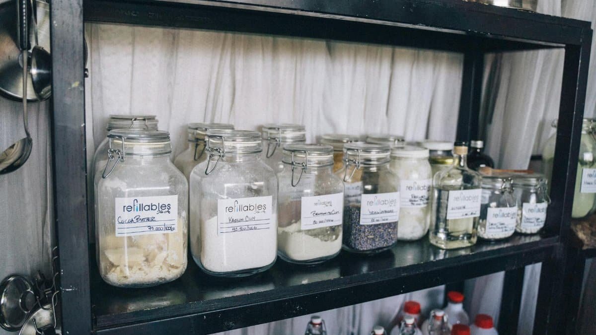 Organized glass jars on a pantry shelf for eco-friendly food storage and sustainability.