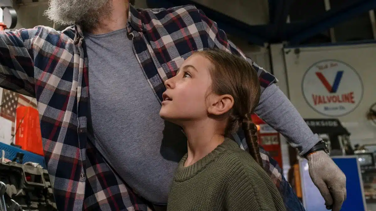Father and daughter bonding while working together in a garage workshop.