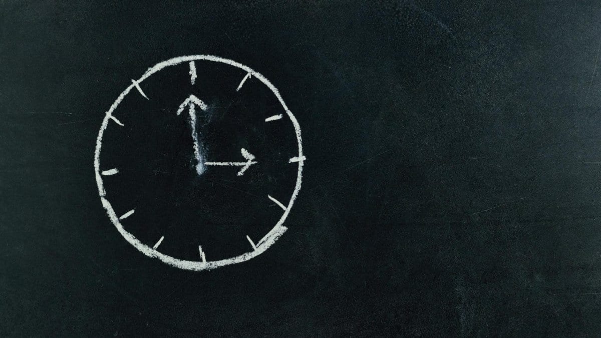 Chalk-drawn clock on a blackboard, symbolizing time and education concepts.