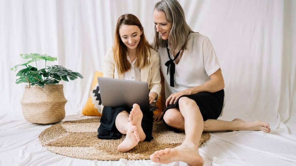 LGBTQ couple happily working together on a laptop at home, embracing remote work lifestyle.