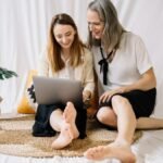 LGBTQ couple happily working together on a laptop at home, embracing remote work lifestyle.