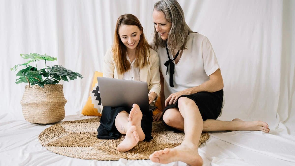 LGBTQ couple happily working together on a laptop at home, embracing remote work lifestyle.