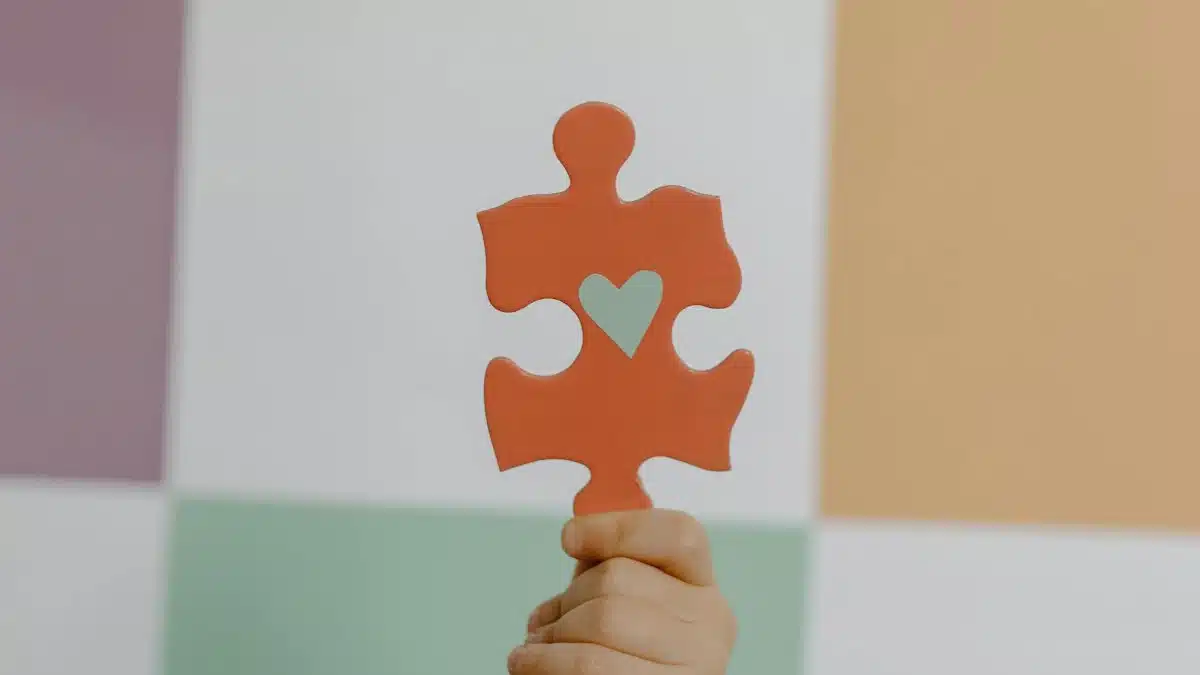 A hand holds a red puzzle piece with a heart, symbolizing connection and awareness.
