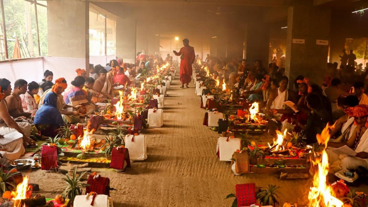 A vibrant and colorful Hindu ritual with participants in traditional attire and ceremonial fires in Dhaka.