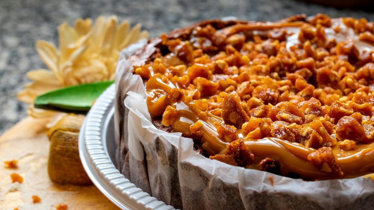 Close-up of a caramel nut crunch cake, showcasing rich textures and colors, enticing food photography.