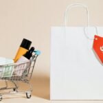 Minimalist image featuring a shopping cart with products and a sale-tagged bag.