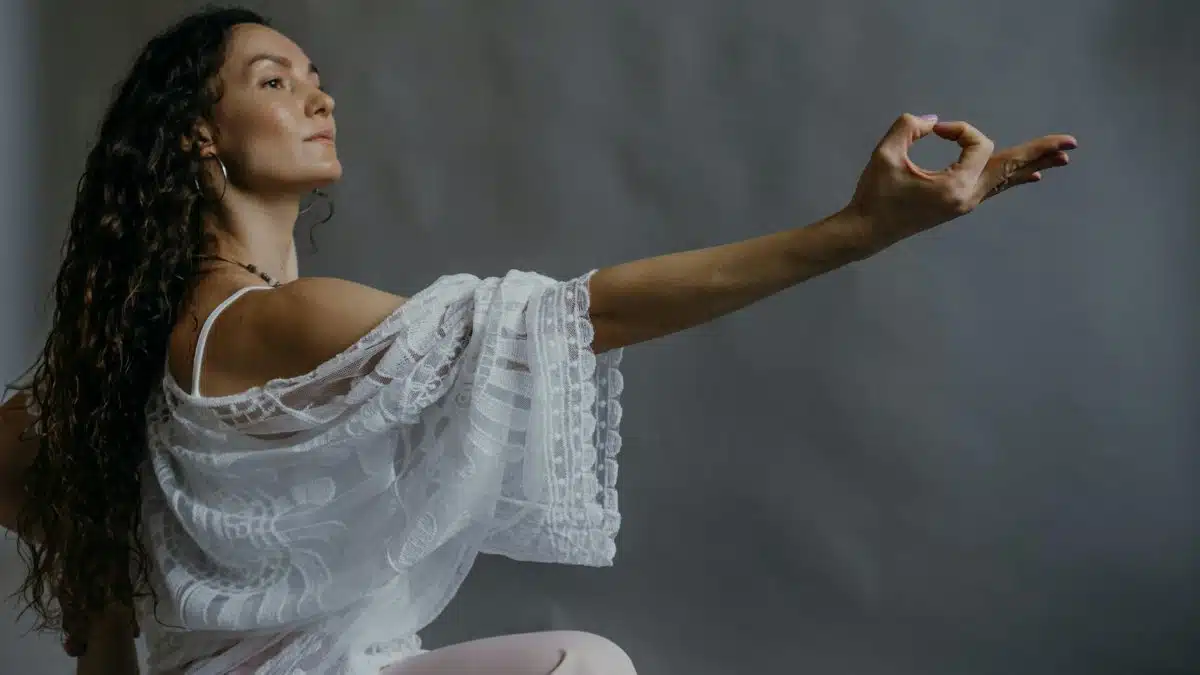Woman practicing yoga pose with graceful expression indoors.