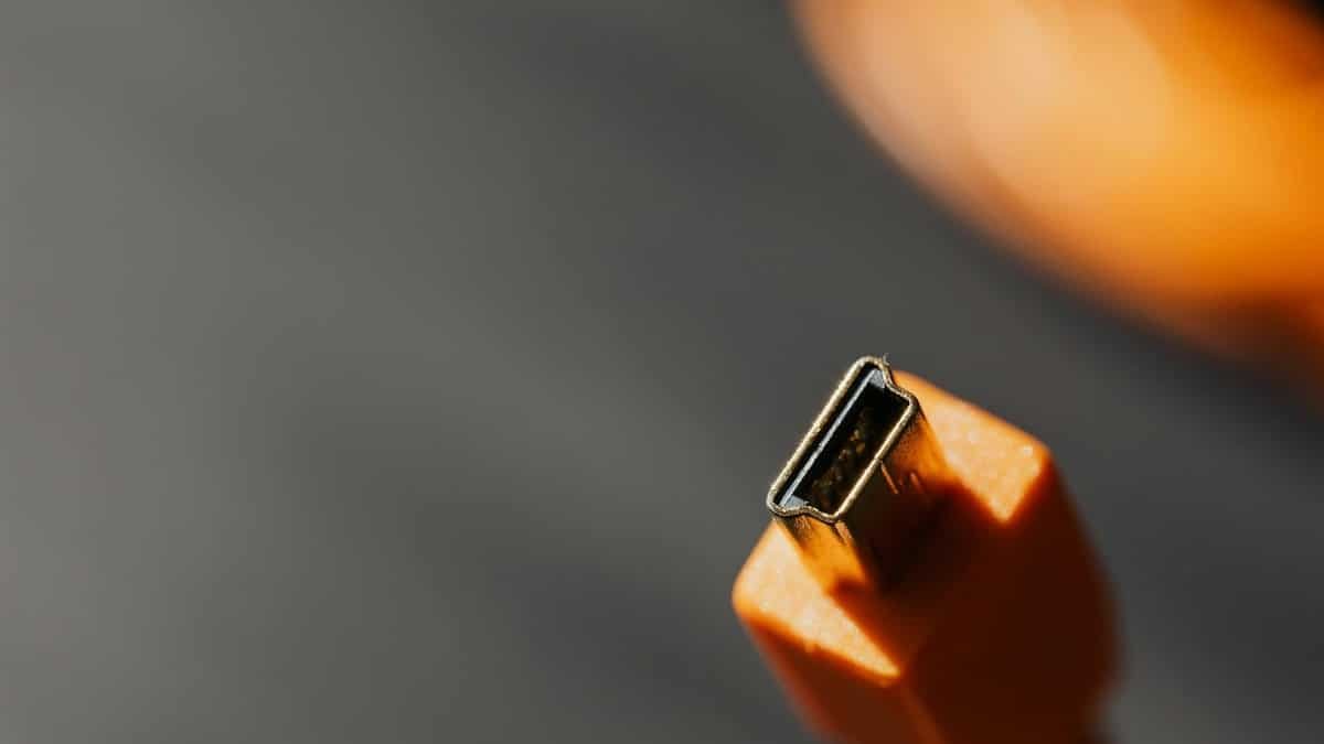 Detailed macro shot of an orange USB connector with a blurred background.