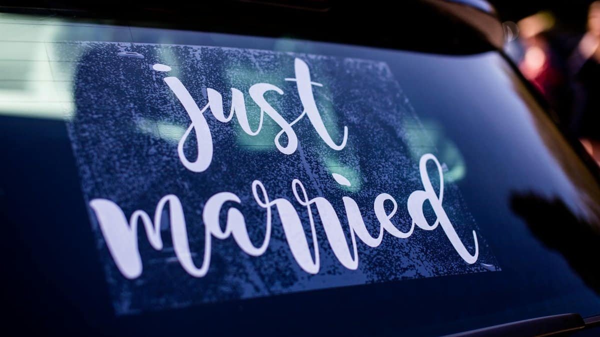 Wedding decoration with a 'just married' sign on a car's rear window, symbolizing celebration and union.