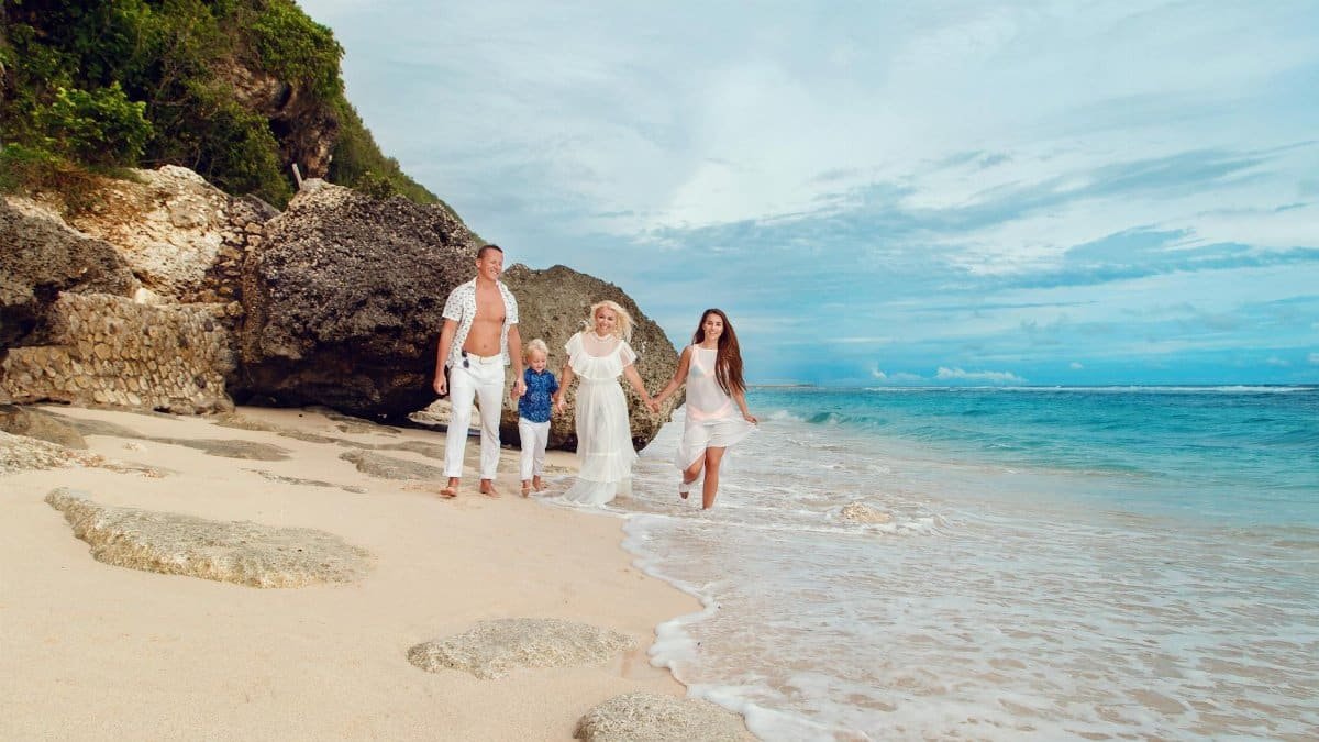 A happy family enjoying a walk on a beautiful Bali beach, capturing a moment of joy and togetherness.