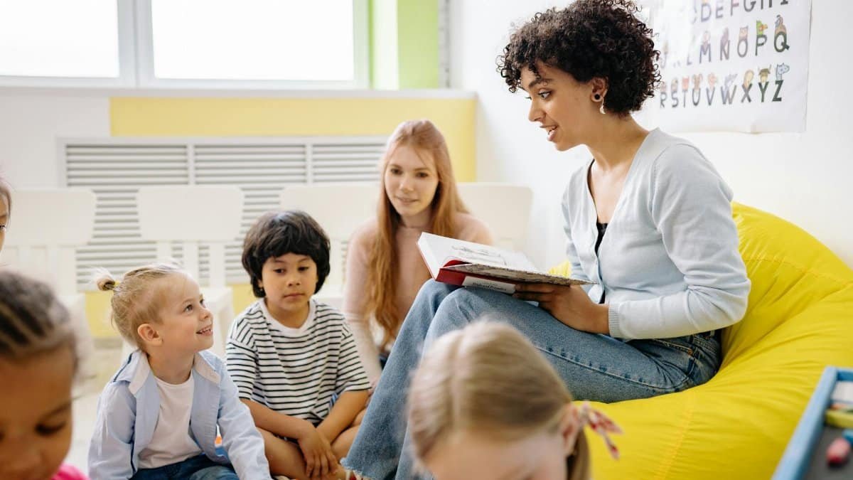 Teacher reading to preschool kids in a colorful classroom setting.
