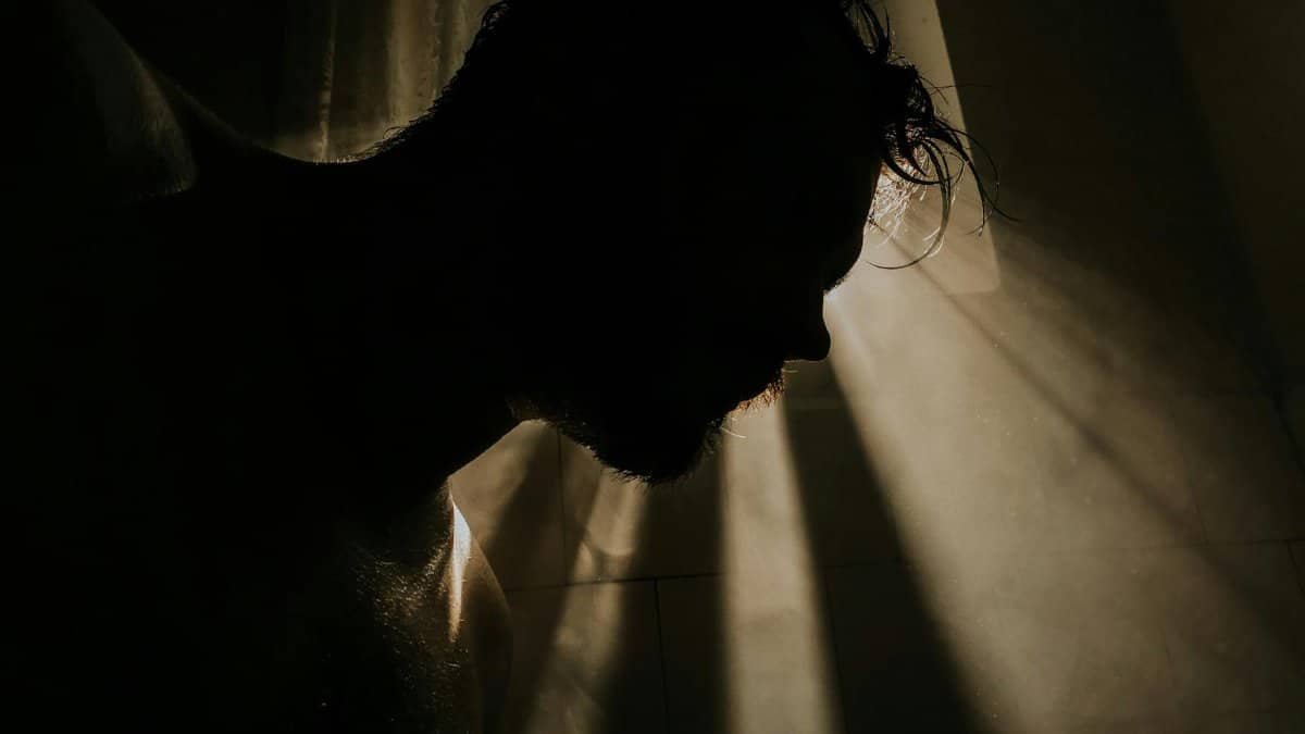 A mysterious silhouette of a man with dramatic lighting and shadows creating an artistic effect.