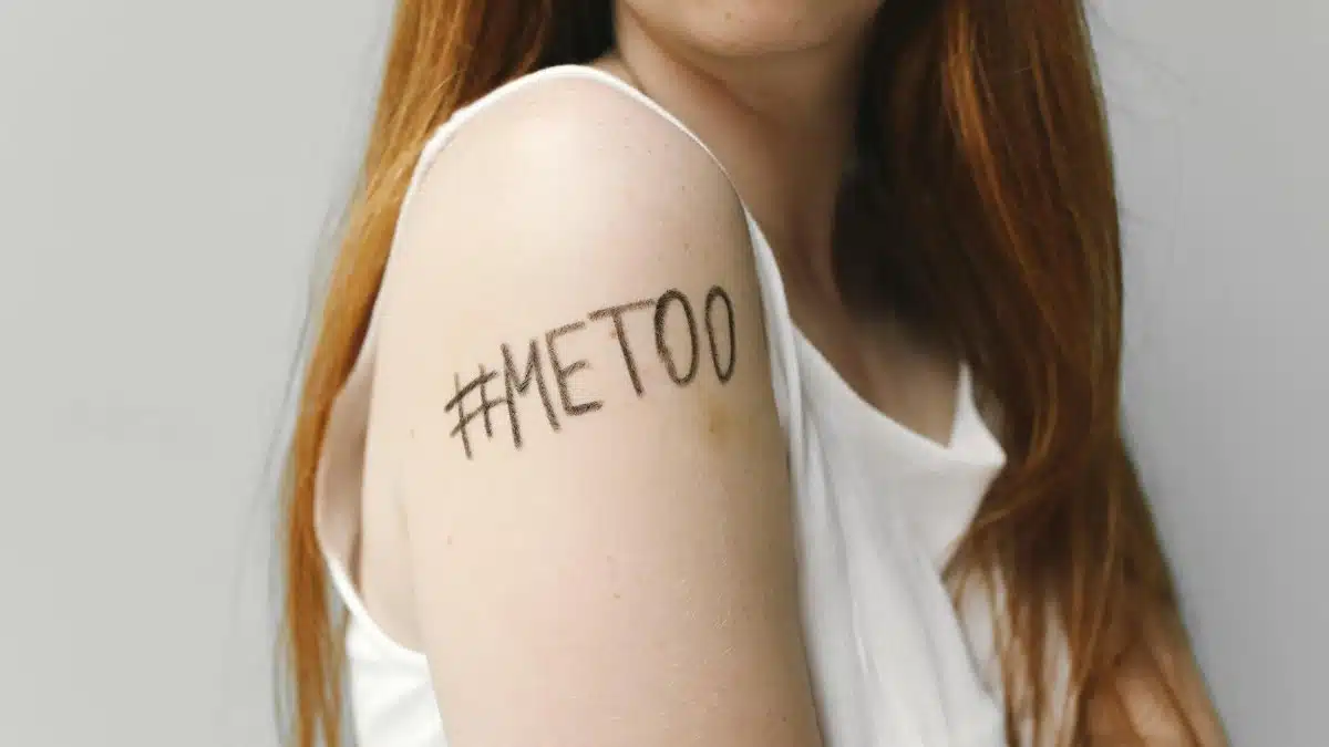 Close-up of a woman with #MeToo written on her arm, symbolizing empowerment and solidarity.