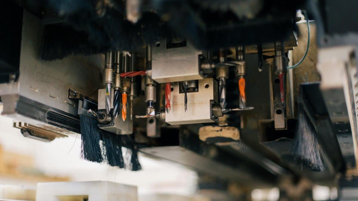Detailed view of an industrial machine with multiple drills and brushes in a factory setting.