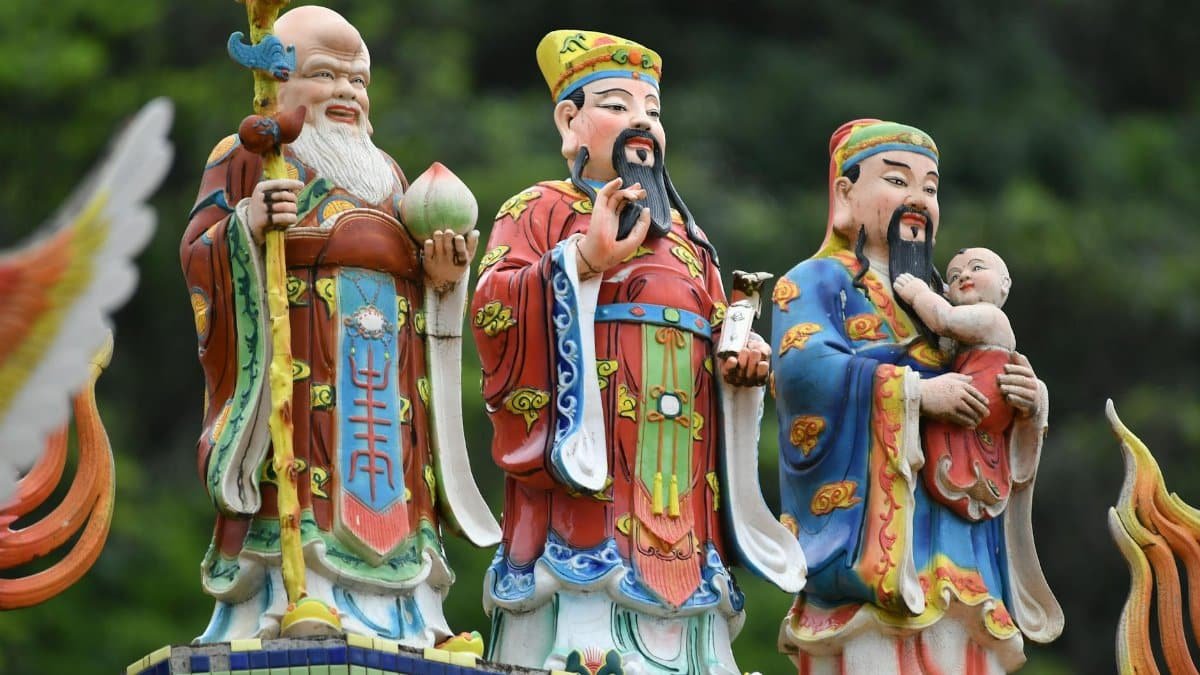 Vibrant statues of Taoist deities captured outdoors, showcasing traditional design.