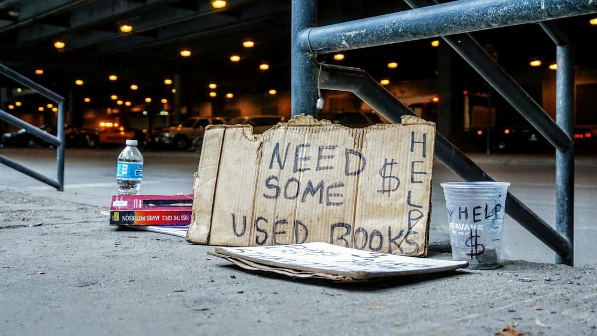 A help sign and used books in an urban setting highlight poverty in Chicago.