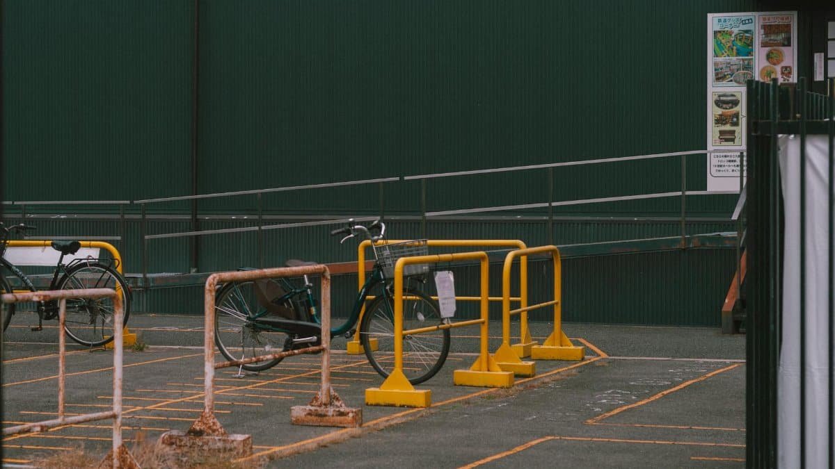 A minimalist bicycle parking area in Japan, featuring a simple urban design and vibrant yellow barriers.