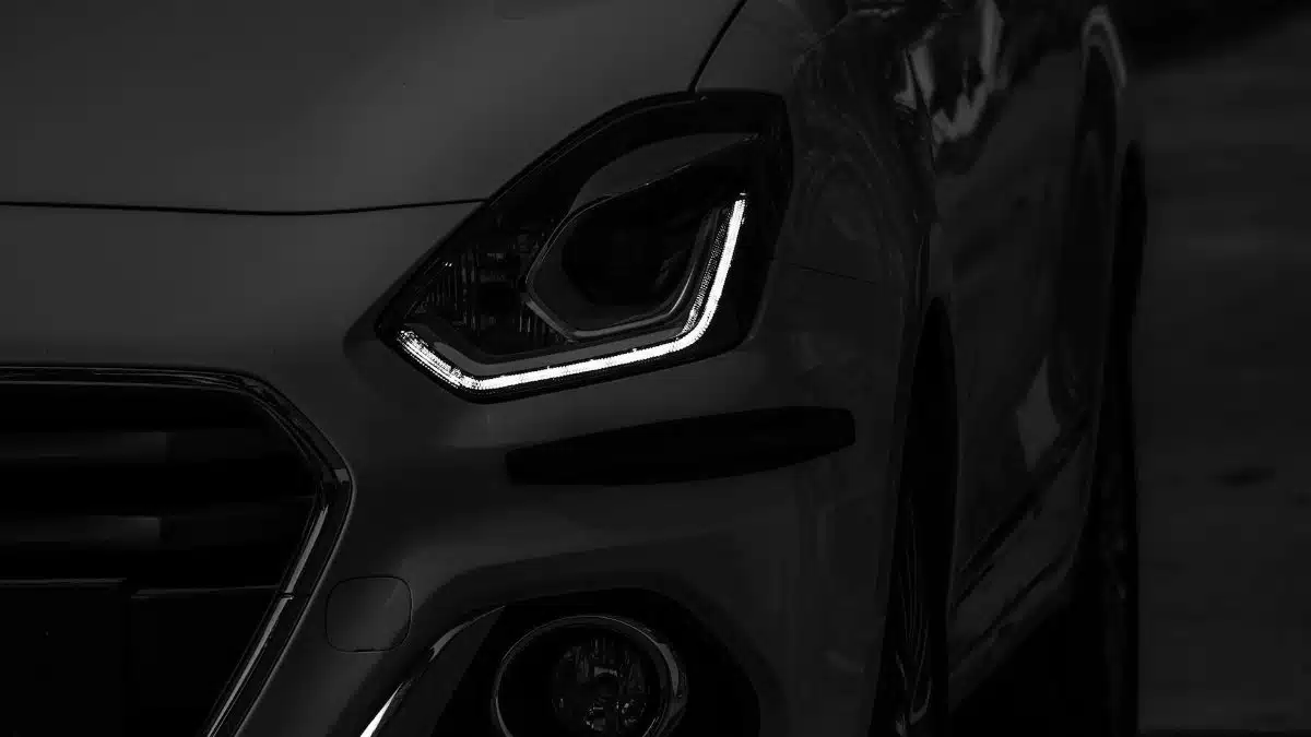 A striking grayscale image showcasing the intricate design of a modern car headlight.