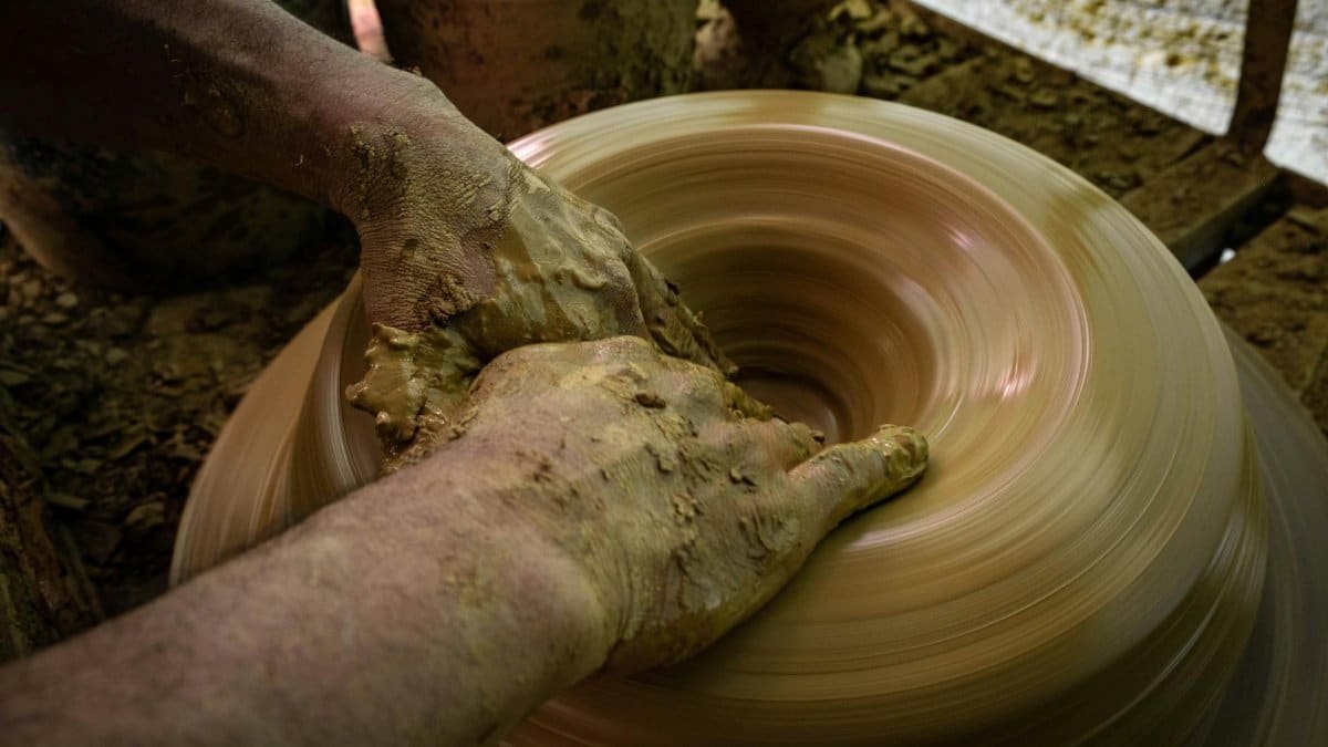 Close-up of hands shaping clay on a spinning wheel in Ráquira, Colombia.