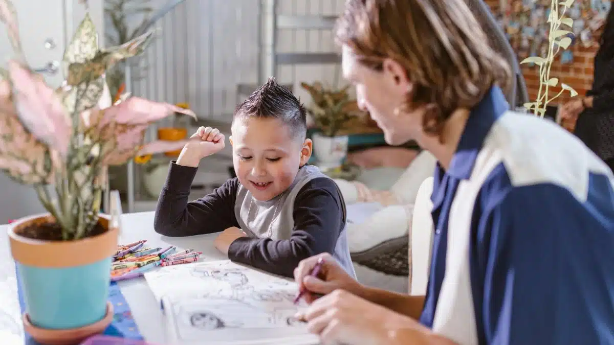 Father and son enjoy quality time and creativity while coloring together indoors.
