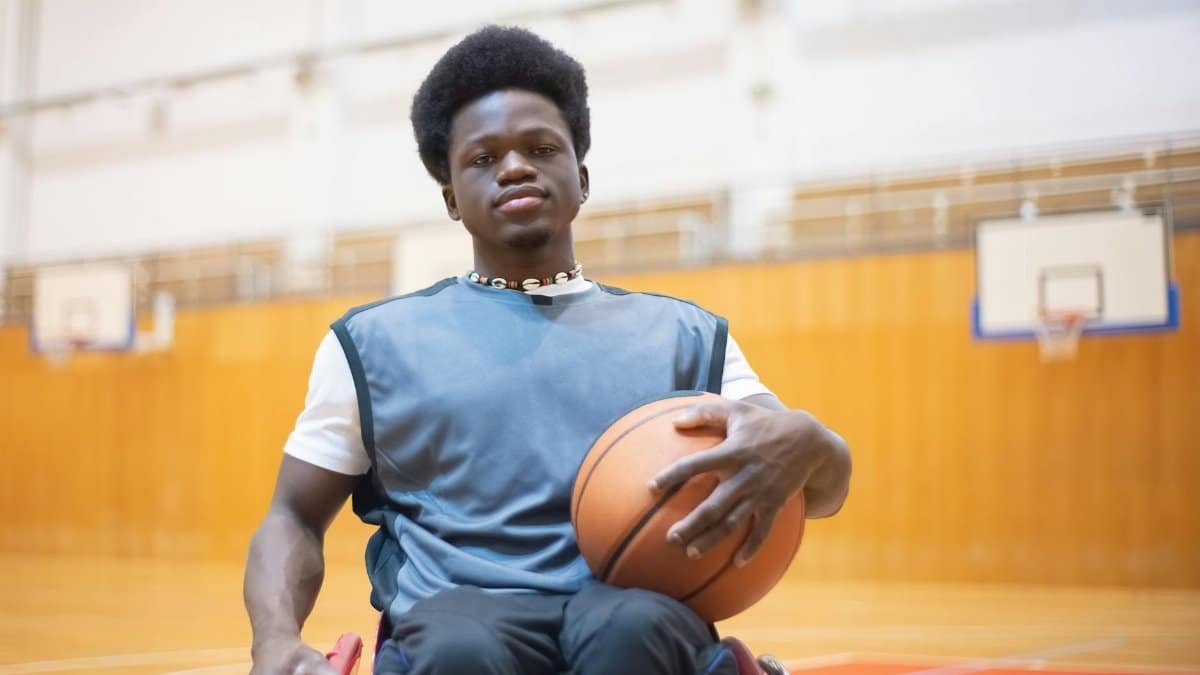 Inspirational young athlete on a basketball court holding a ball with determination.
