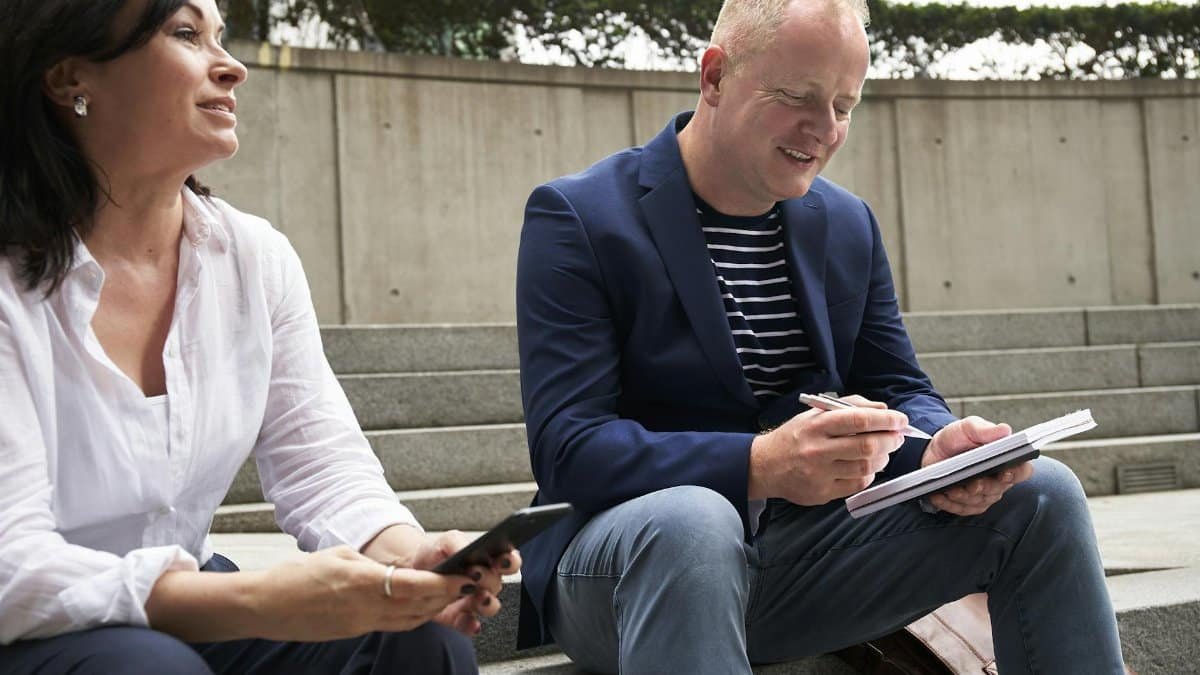 A man and woman engage in a work-related discussion outdoors in London.