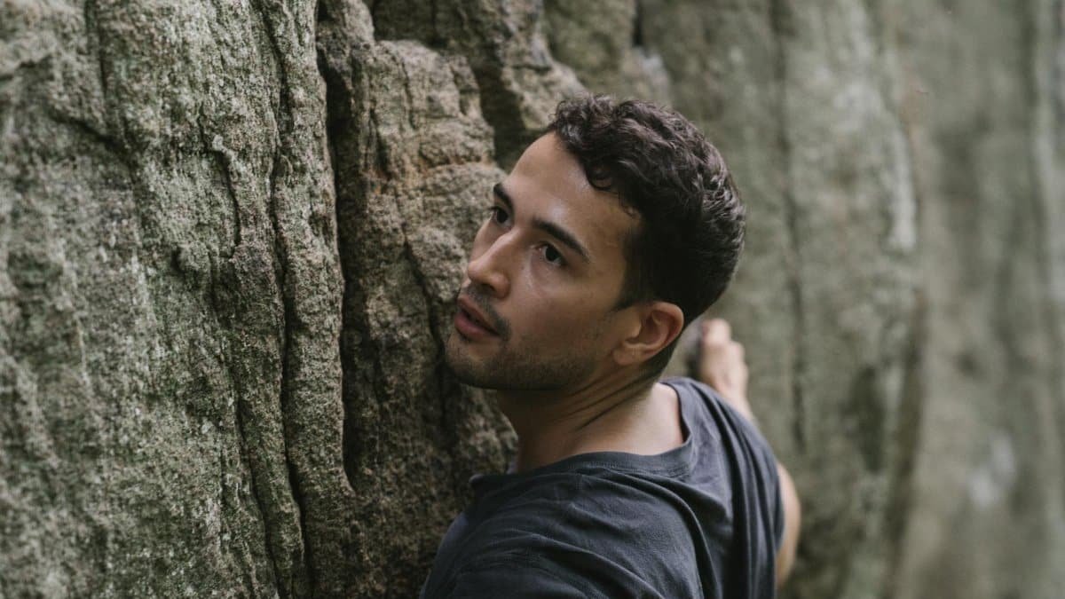 Intense moment of a climber engaged in rock climbing adventure, showcasing determination.