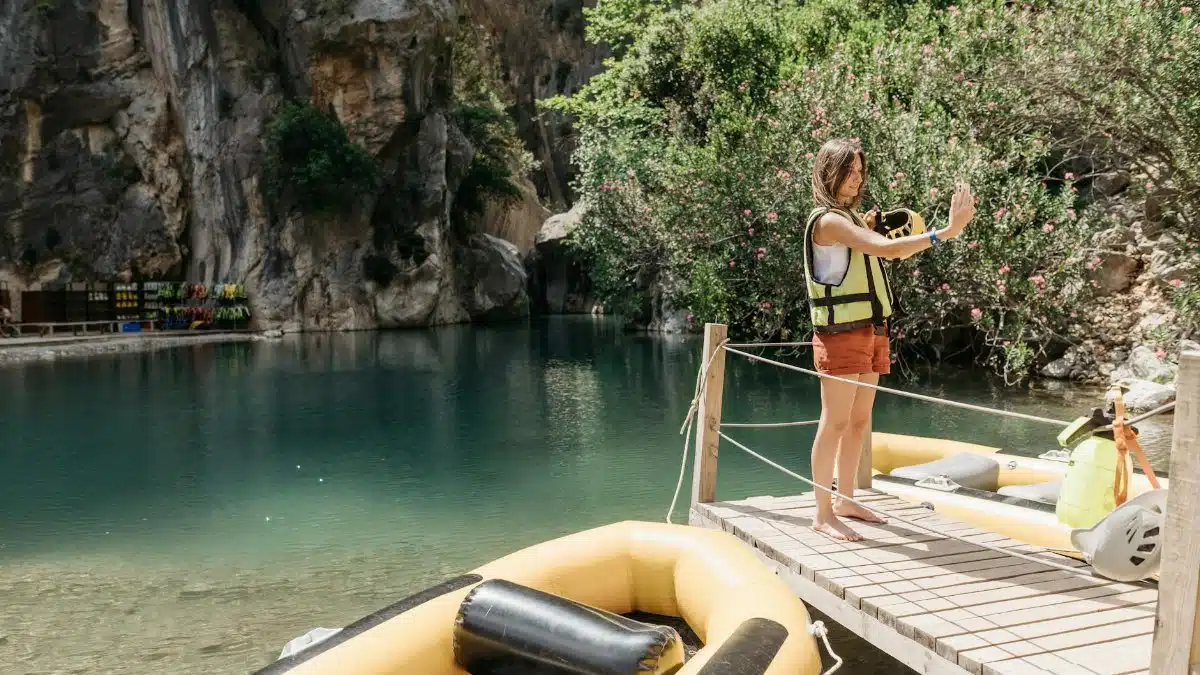 A woman in a life vest takes a selfie at Goynuk Canyon by the water.