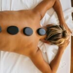A serene hot stone massage therapy session with smooth black stones placed on the back for relaxation.