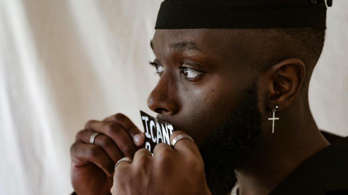 Close-up of a man with a sign reading 'I Can't Breathe,' evoking social justice themes.