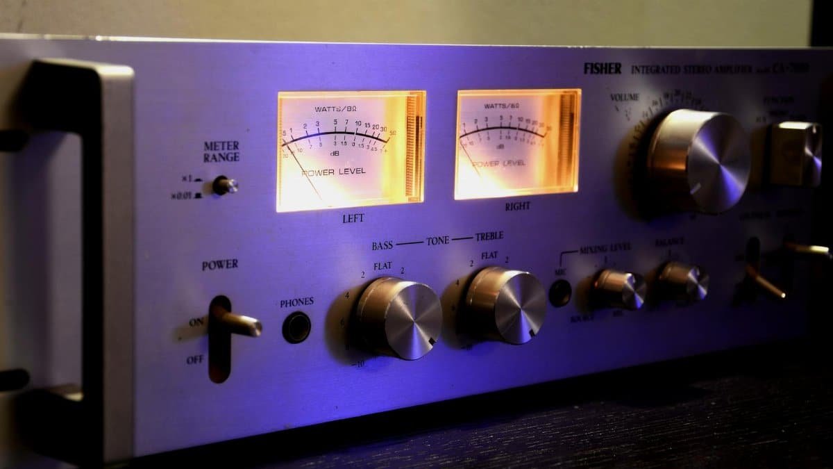 Close-up of a vintage stereo amplifier with glowing dials and controls.