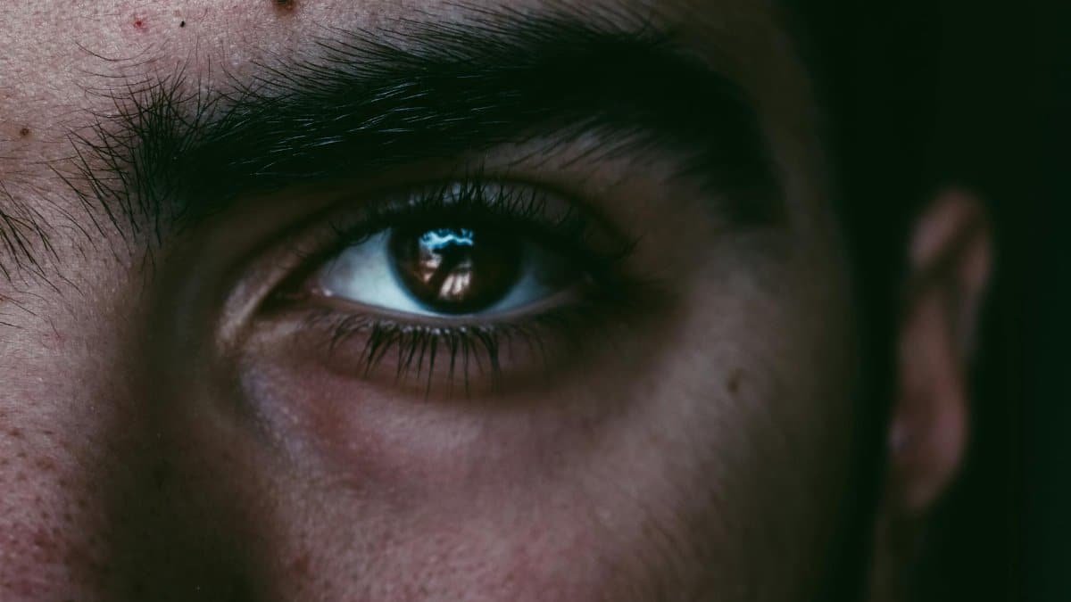 A focused close-up of a man's eye, capturing a deep gaze under natural light.