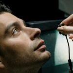 Close-up of a man in a lab setting looking up during an eye examination for medical analysis.