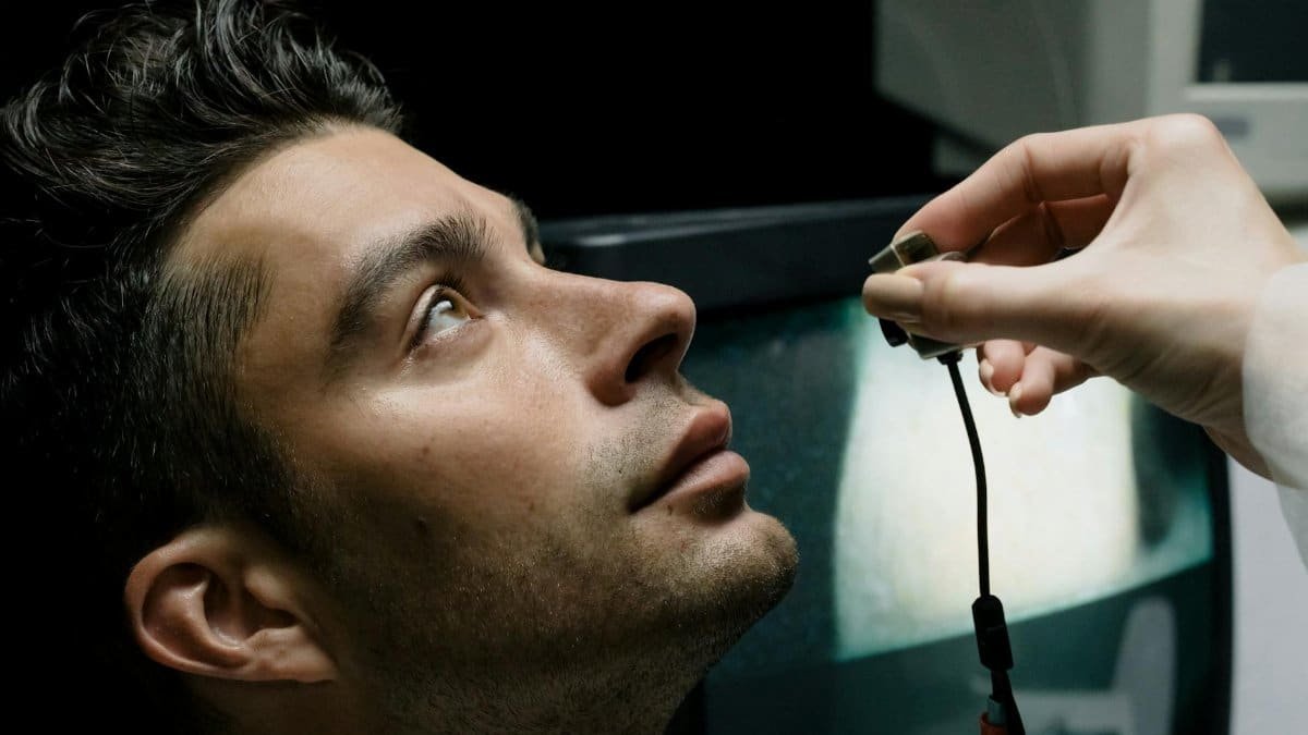 Close-up of a man in a lab setting looking up during an eye examination for medical analysis.