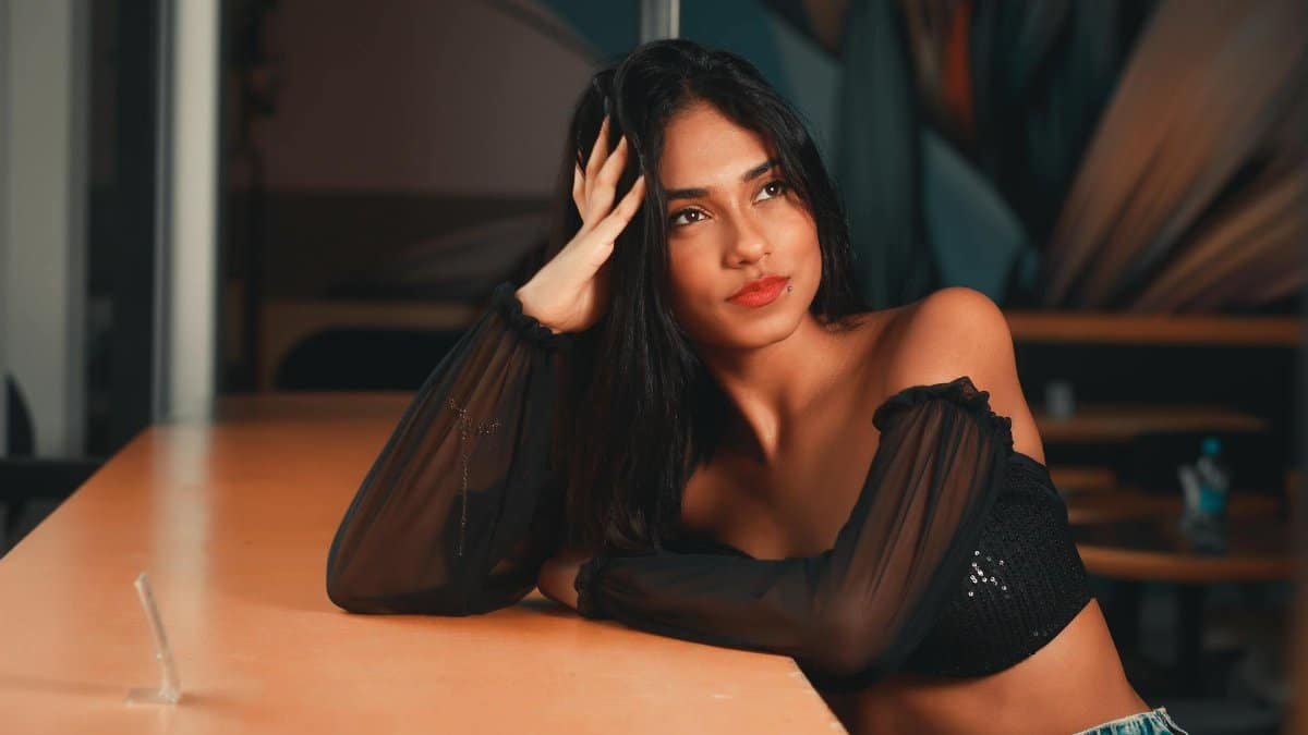 Elegant portrait of a young brunette woman posing stylishly indoors, exuding modern fashion trends.