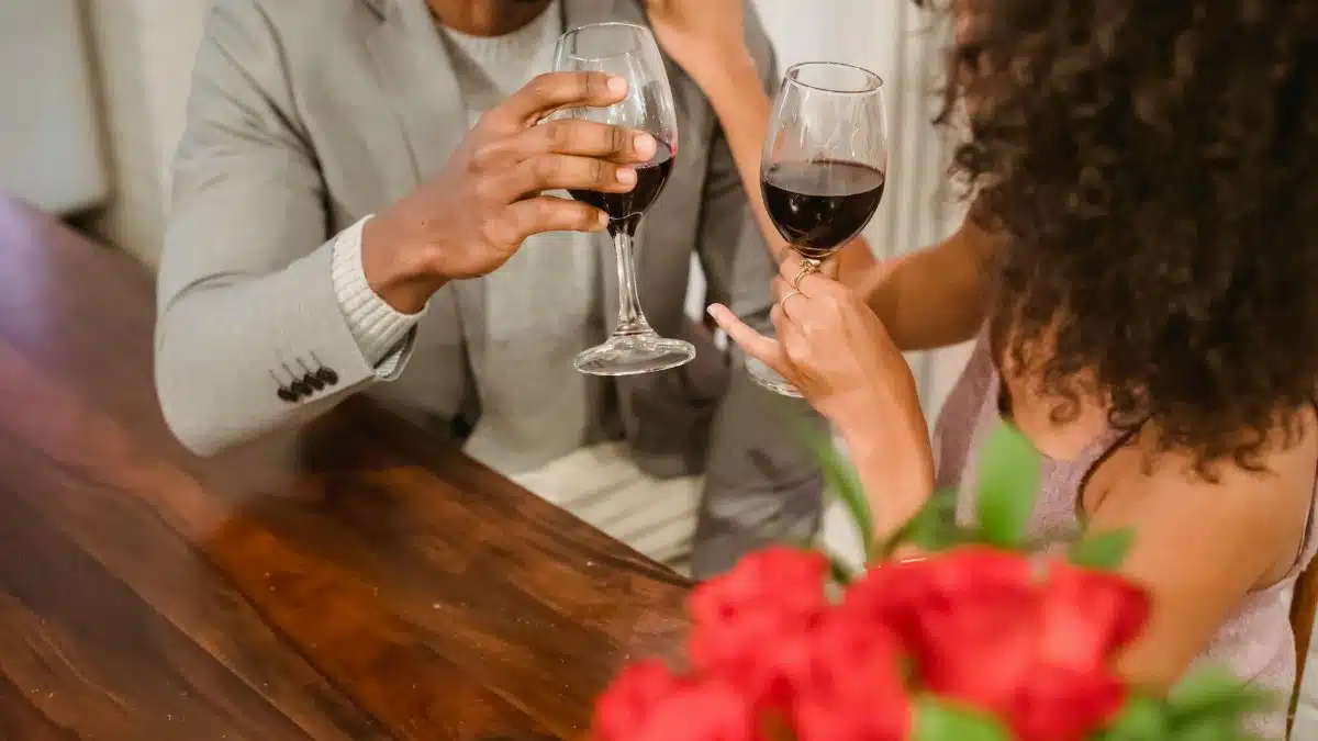 A romantic moment as a couple toasts with wine at home. Perfect for Valentine's Day.