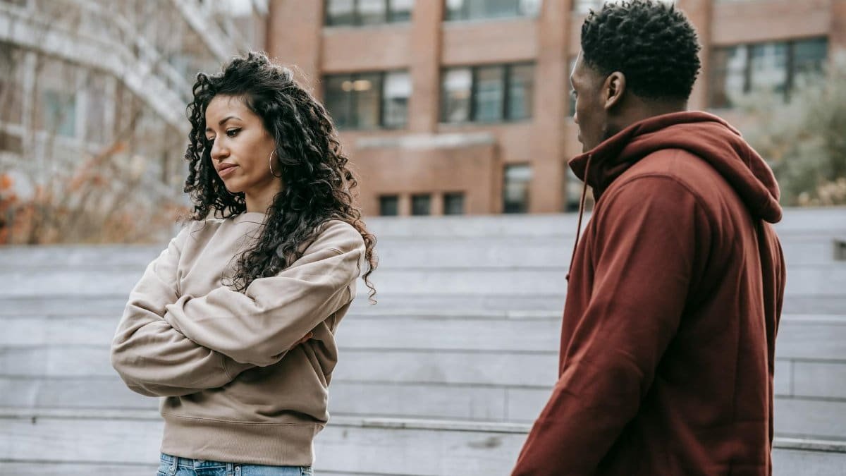 A couple in a heated argument outside, displaying frustration and dissatisfaction.
