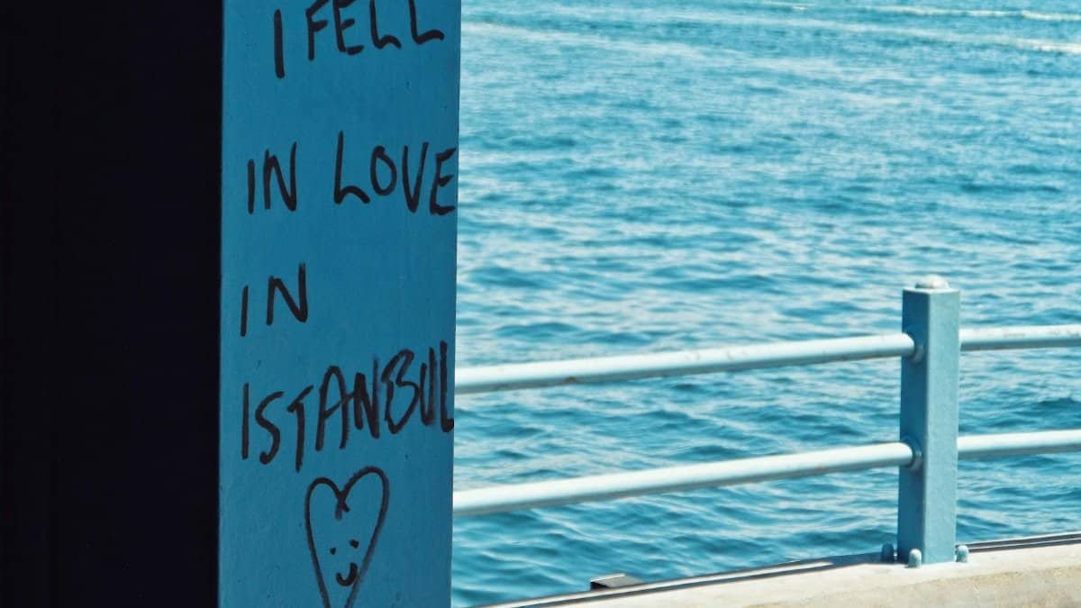 Graffiti reading 'I fell in love in Istanbul' with a heart by the sea.