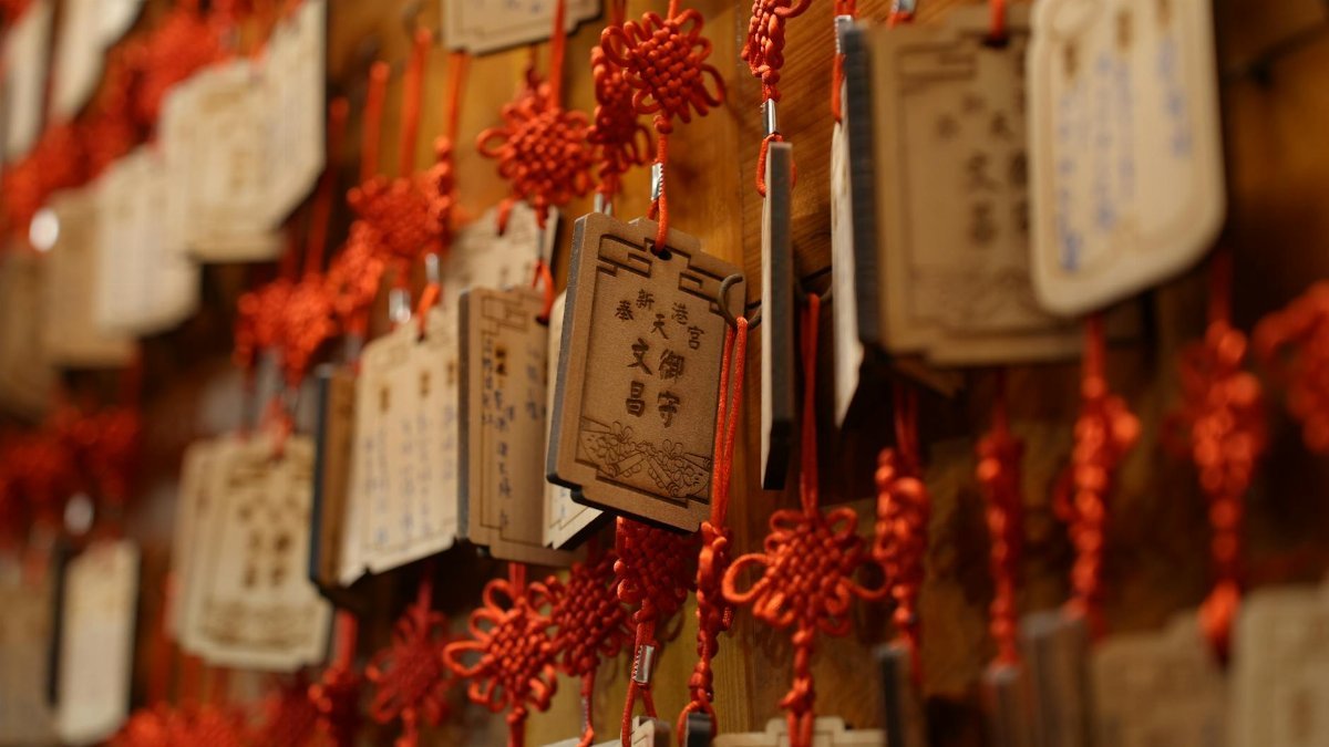 Hanging wooden prayer plaques with red knots in Chiayi County, Taiwan, symbolizing cultural heritage.