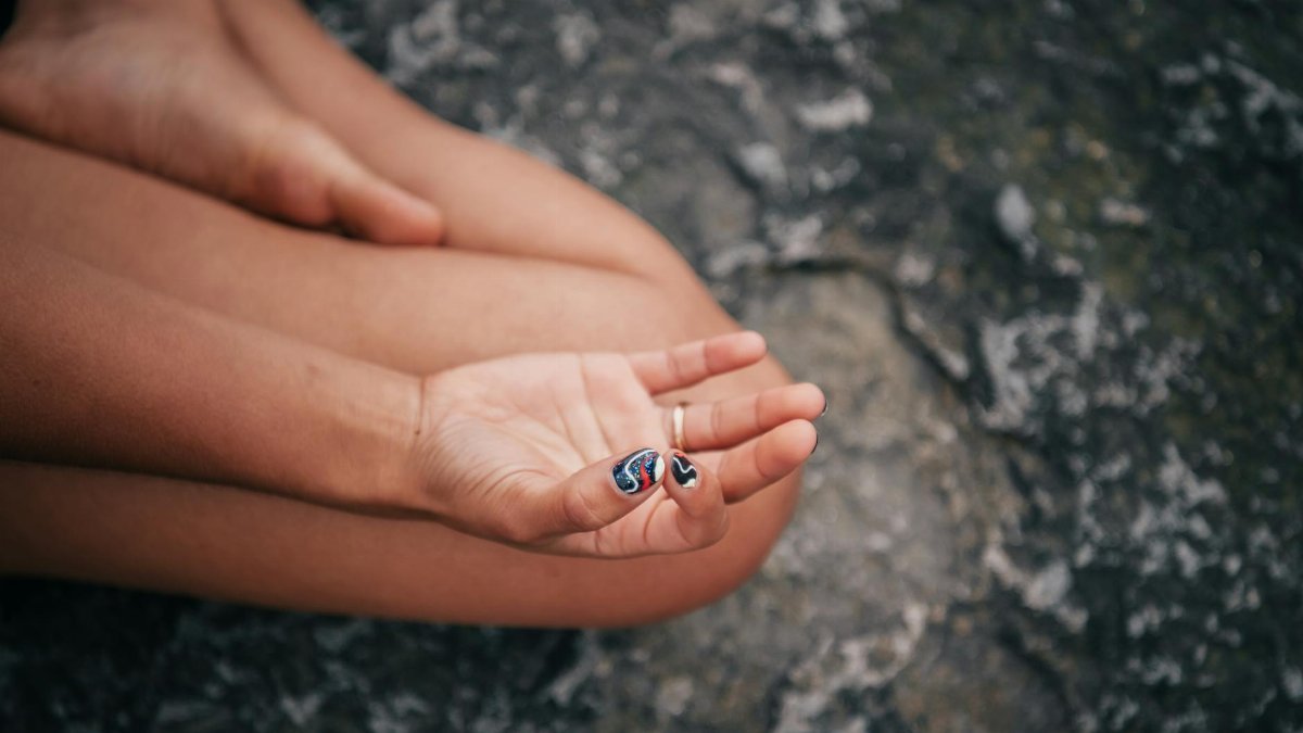 Close-up of a hand in gyan mudra, symbolizing peace and mindfulness during meditation.