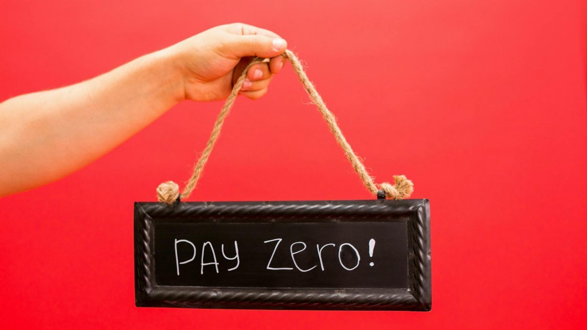A hand holds a sign displaying 'Pay Zero' on a vibrant red background, emphasizing a free or zero-cost concept.