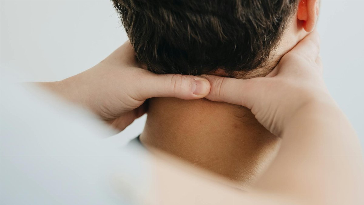Close-up of a therapist massaging a patient's neck for pain relief and relaxation.