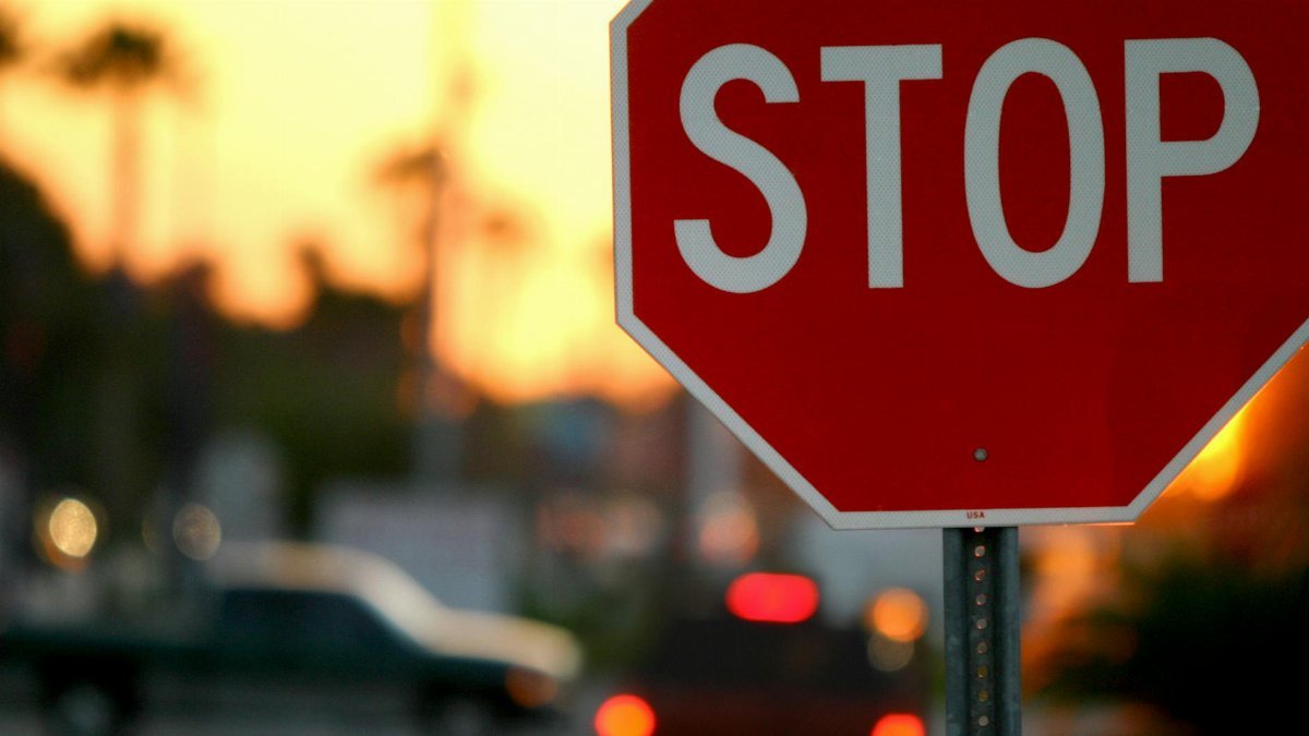 A stop sign with blurred traffic and vibrant sunset in Kissimmee, FL.